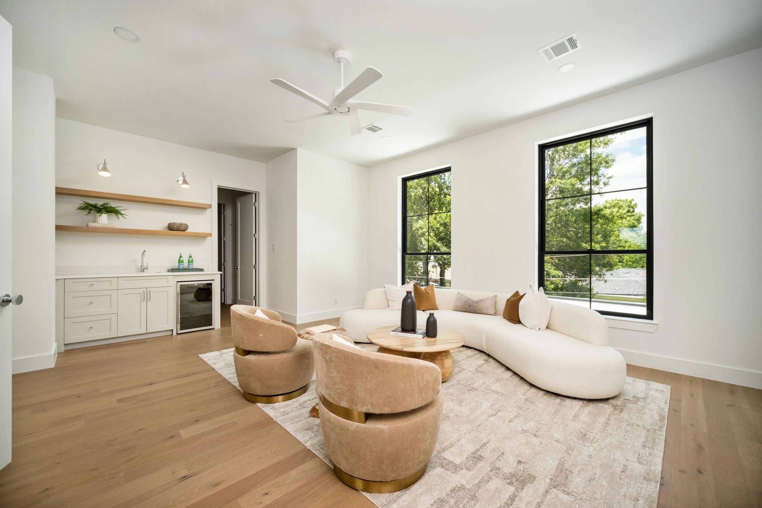Bright open-concept living space with curved sofa and large windows